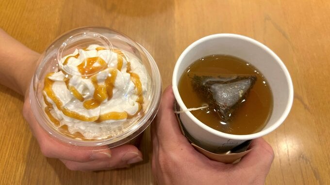 カフェで甘いドリンクと紅茶を持っている