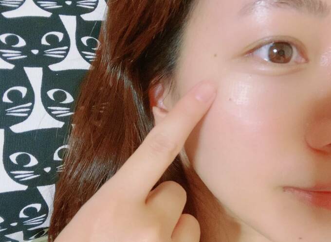 頬を指さす女性