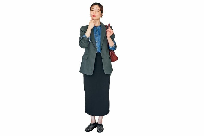 リップを塗る、シックなジャケットとタイトスカートの女性