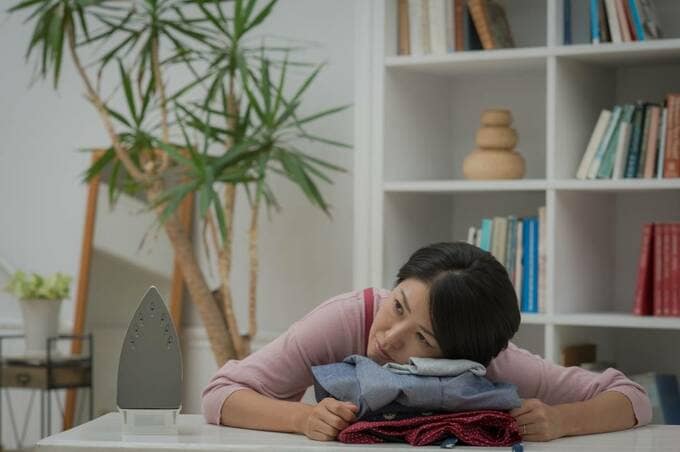 衣類の上に頭を置く女性