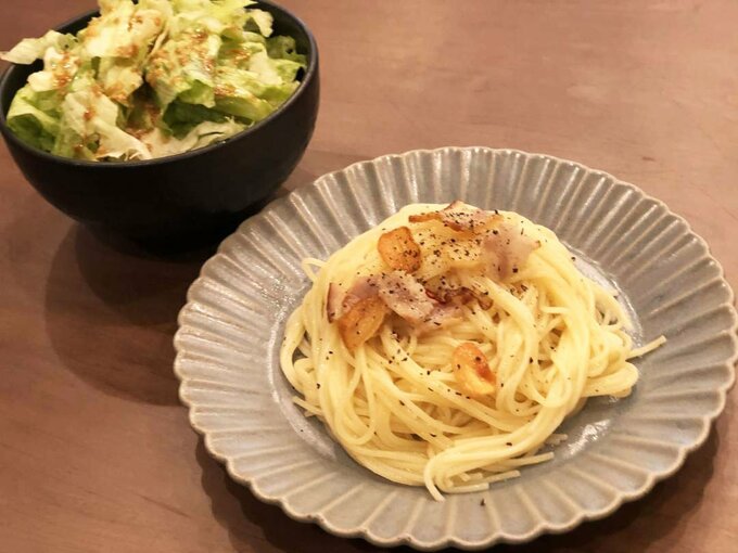 サラダとニンニクがのったパスタ