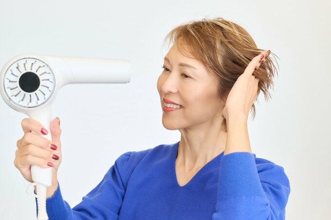 ドライヤーをする女性