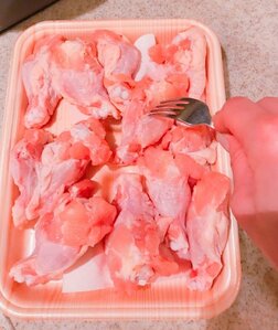 鶏の手羽元をフォークで刺す