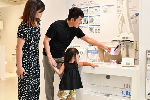 トイレの仕組み展示コーナーで親子3人