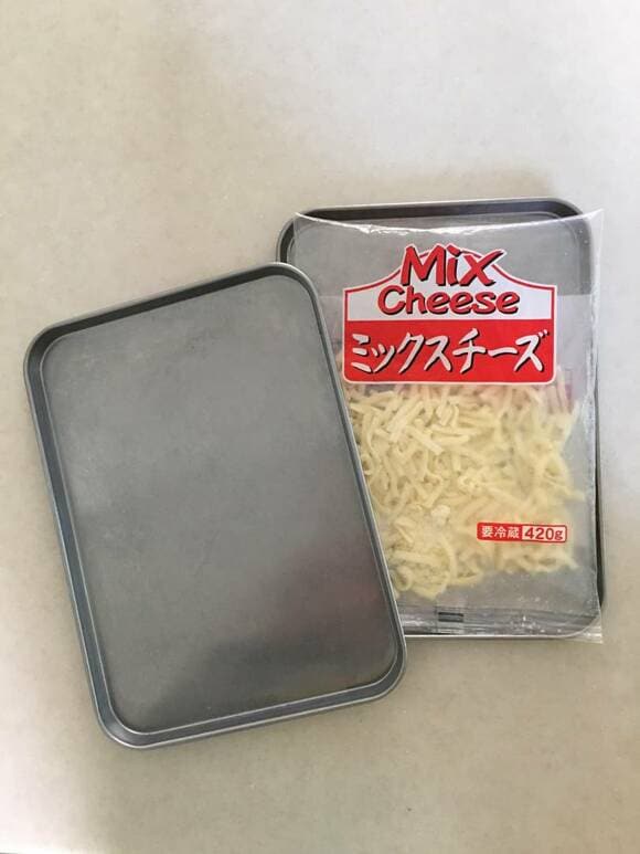 ピザ用チーズを金属トレーで挟む