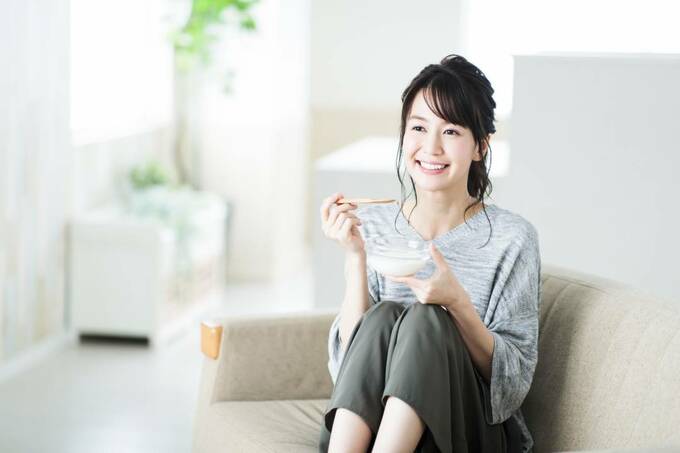 ソファで食事する女性