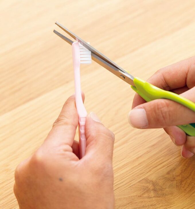 歯ブラシをハサミでカットする様子