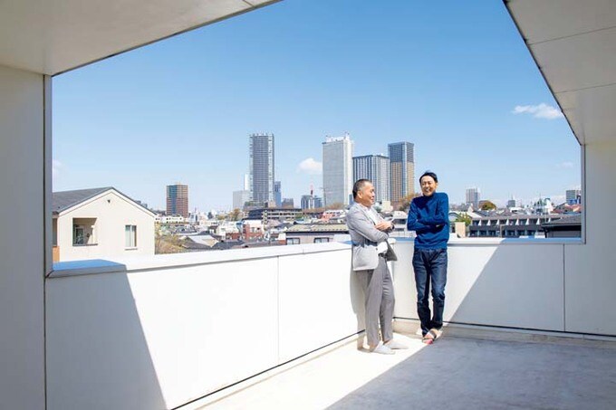 景色を一望できる屋上テラスで話す田中さんと河内さん