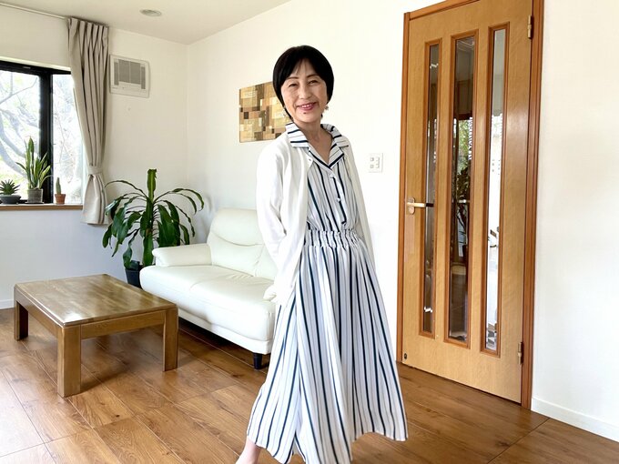 オフホワイトのカーディガンにストライプのワンピース