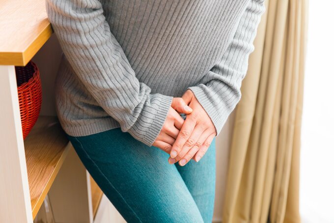 股をおさえる女性