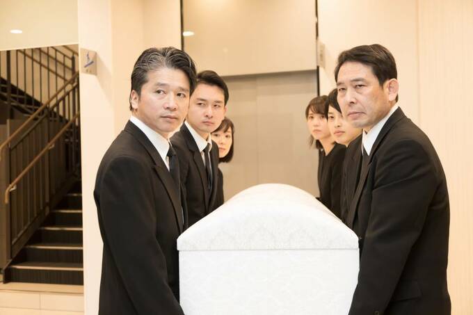 棺桶を持つたくさんの人