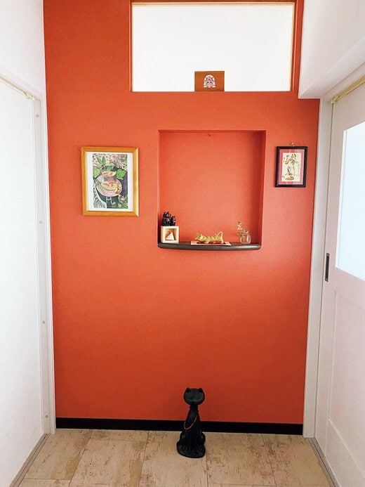 オレンジの壁紙が印象的な玄関
