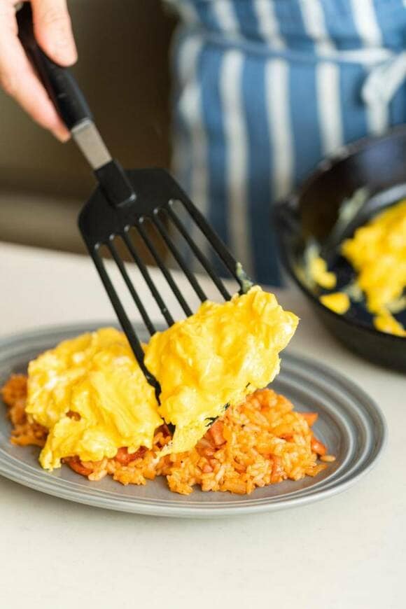 ケチャップライスに卵をのせている様子