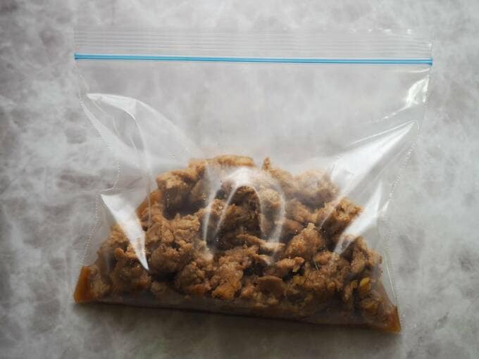 ジッパーつきビニール袋にすりおろしたショウガ、ニンニク、しょうゆ、酒を入れ、大豆ミートを加える