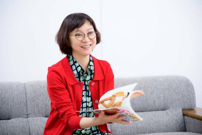 雑誌を見て話す尾崎真佐子編集長