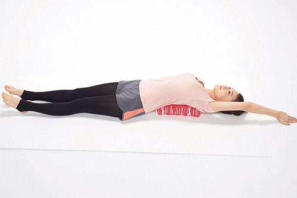 左肩甲骨の下に枕を置き、腕を伸ばしてキープ