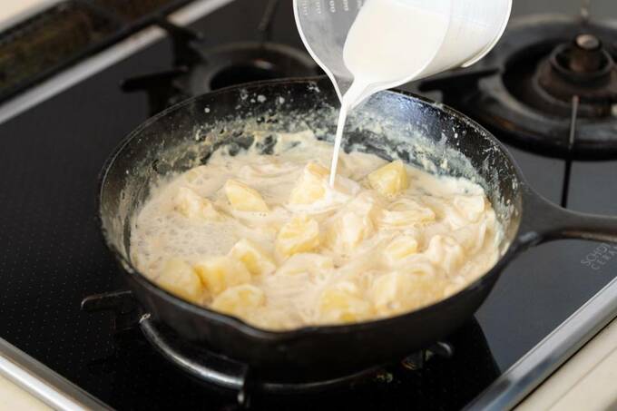 タマネギやジャガイモを牛乳で煮ている様子
