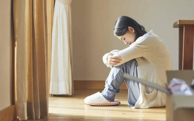 膝を抱える女性