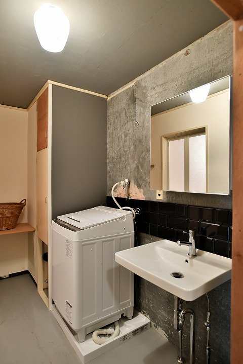 現しと黒タイルで壁を仕上げたサニタリー