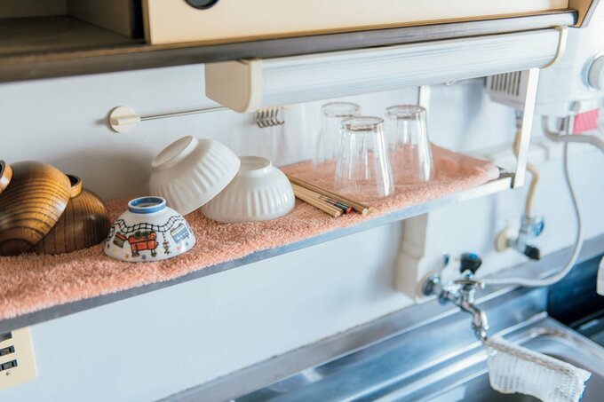 つり戸棚のラックにタオルを敷いて水きりカゴの代用をしている様子