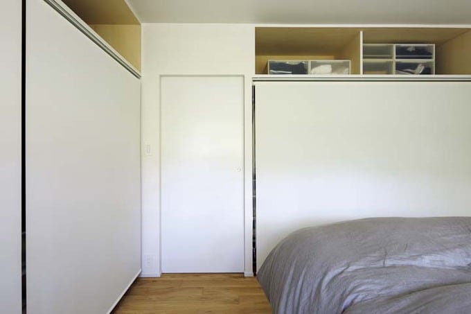 壁の2面に収納を設けた寝室
