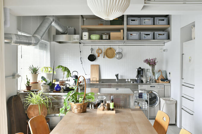 白いタイルの壁に映えるステンレスキッチン