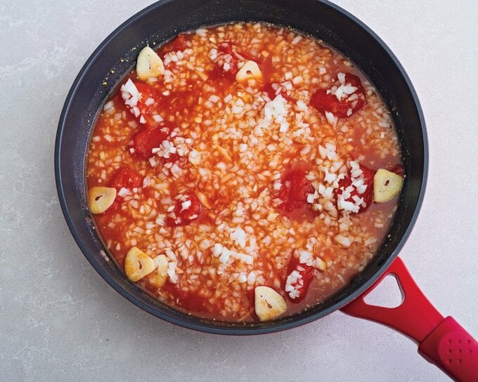 フライパンにニンニクなど調味料