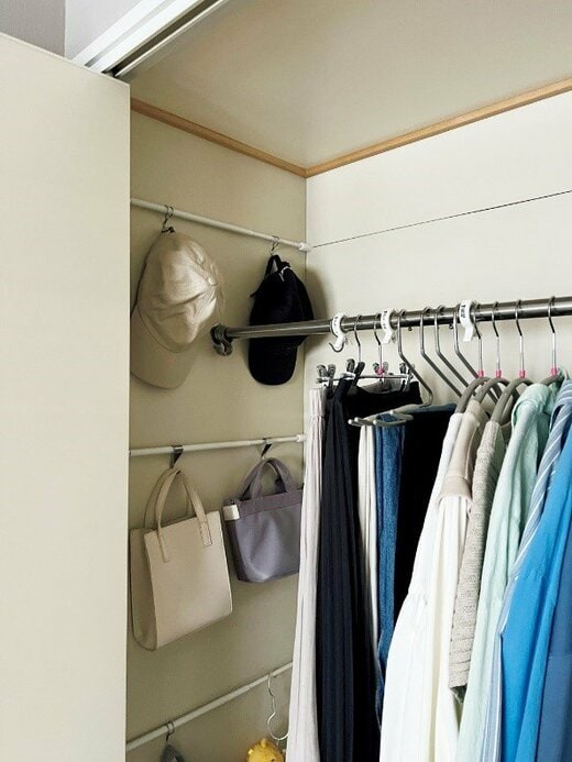 壁につっぱった棒にかけて収納される帽子