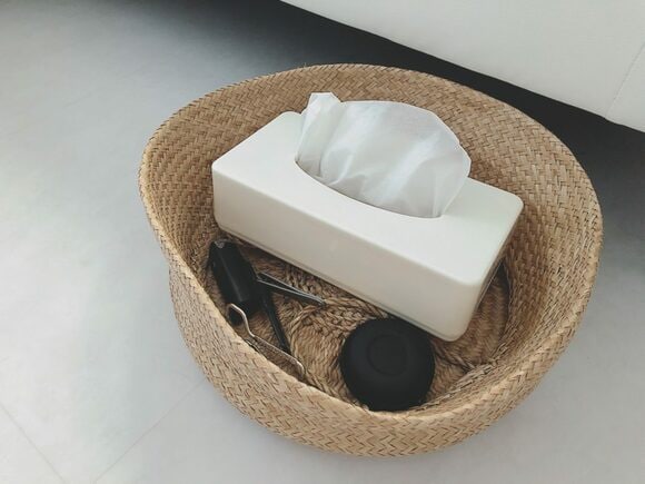 こまごまとしたものをカゴにひとまとめにして、ソファ下に