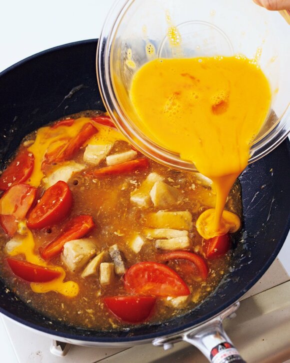 中華鍋に生卵を入れる様子