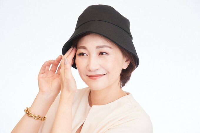 帽子に髪をしまう女性