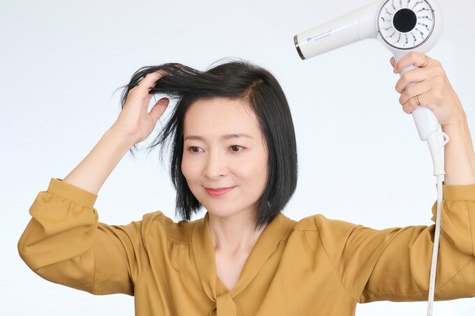 ドライヤーを当てる女性