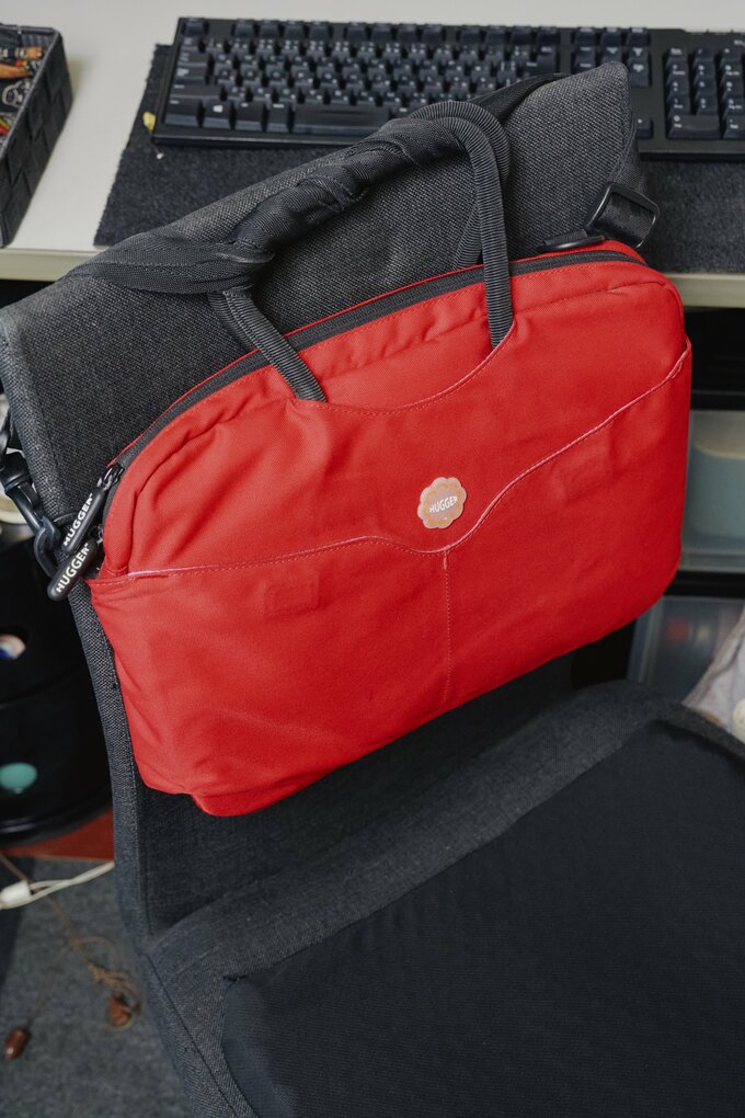イスの背もたれにかけたノートPC用のバッグ