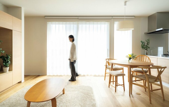 女性が中央にたたずんでいるリビングの写真