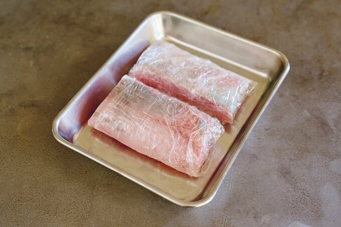 塩で下味をつけラップで包んだブリ