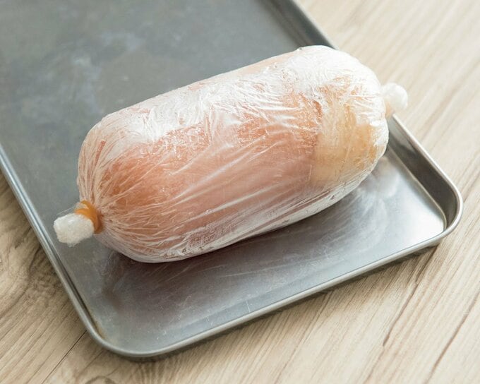 鶏ハム用に下味をつけてラップに包んだ鶏胸肉の様子