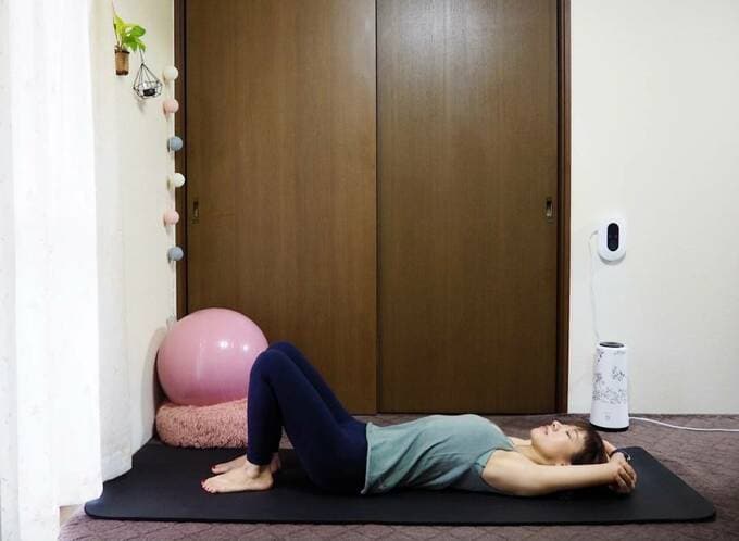 両腕を頭上に戻し、ひじを曲げてそれぞれ手でつかむ