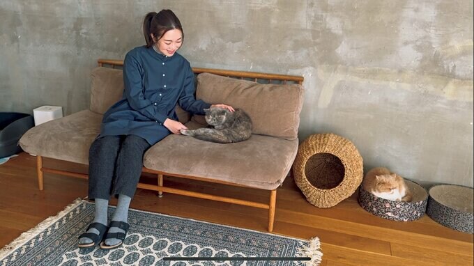 ソファに座りネコを撫でるEmiさん