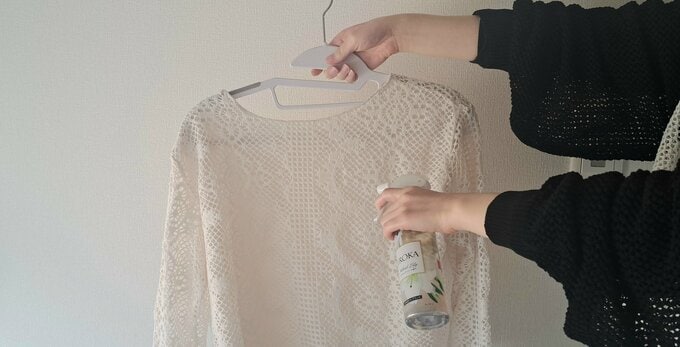洗濯物に消臭スプレーをかける
